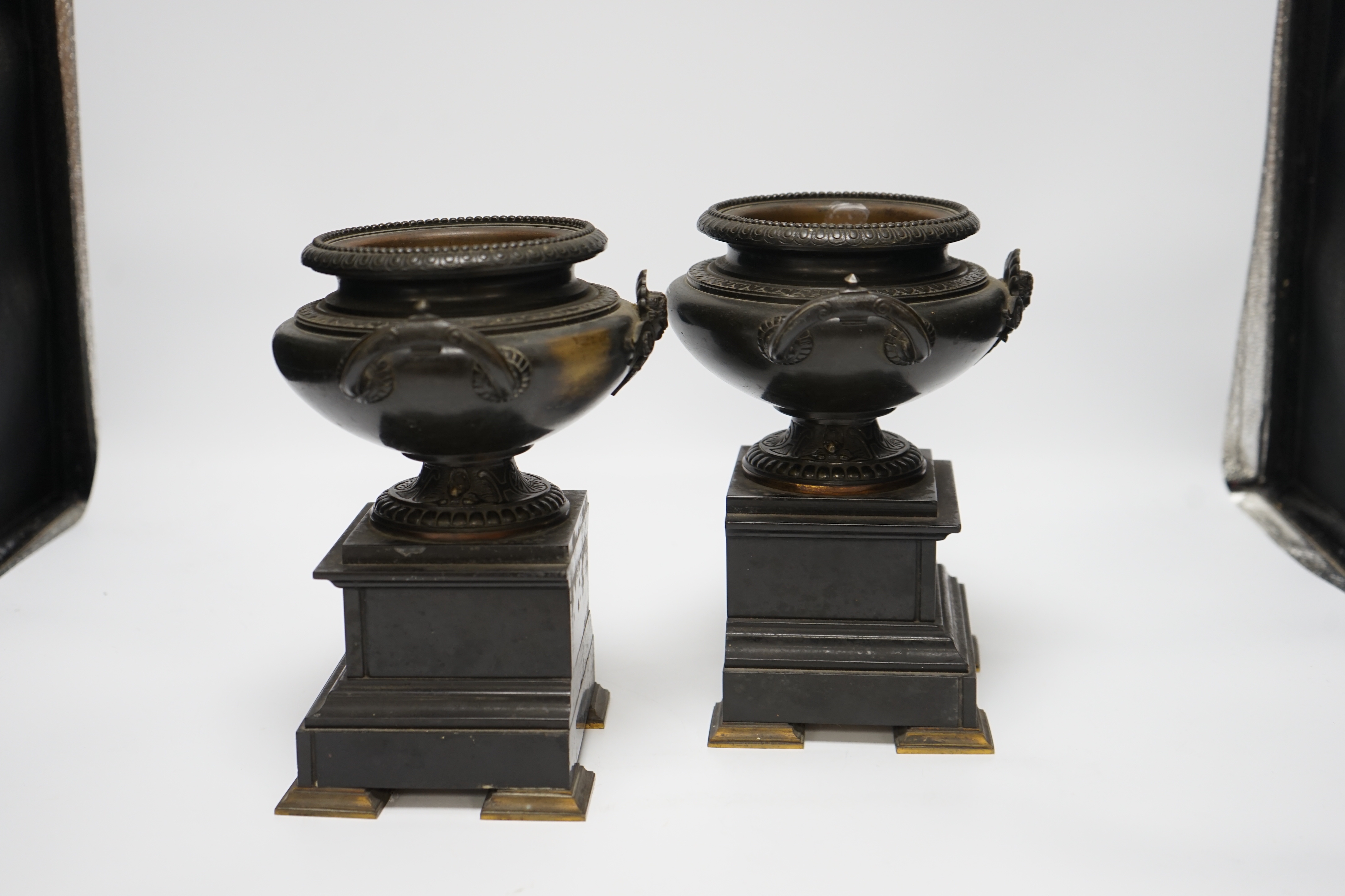 A pair of 19th century bronze urns on slate pedestals, 21.5cm high